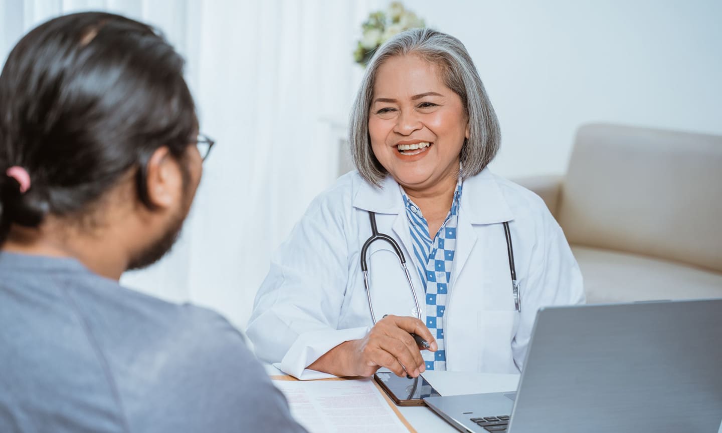 A primary care physician speaks with a patient about their care plan.