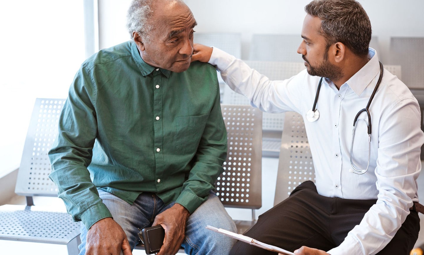 A doctor greets a patient in the waiting room of an FQHC.